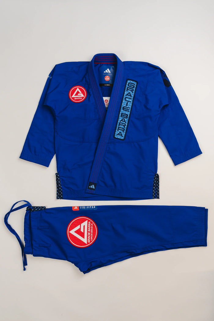 Blue Ripstop Lite Men’s BJJ kimono set by adidas and Gracie Barra, featuring military-grade ripstop jacket and drawstring pants with embroidered Red Shield patches.