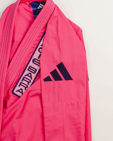Front jacket detail of pink Ripstop Lite Women’s BJJ kimono by adidas and Gracie Barra, showing “Gracie Barra” embroidered lapel trim and purple adidas logo on the sleeve.