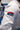 Close-up of the sleeve of the white ripstop kimono jacket, showing the red Gracie Barra patch above a navy Jiu-Jitsu patch on the upper arm