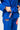Student tying the blue belt over the Ripstop Lightweight womens kimono, showing the GB hem tab and Gracie Barra Jiu-Jitsu label on the pants