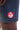 Close-up of the red Barra Shield logo printed above the hem on the leg of the charcoal Gracie Barra Red Shield Classic Premium Boardshort.