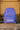 Gracie Barra Sakura kids backpack in purple with pink and white floral print, standing on a wall outdoors