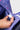 Person placing a small item into the interior mesh organization pocket of the Purple Sakura Backpack