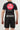 Rear view of youth model wearing Sakura V3 Youth Training Shorts in black with elastic waistband and Gracie Barra branding, paired with black Gracie Barra rashguard featuring large Red Shield logo on back