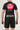 Back view of youth wearing Sakura V3 black rashguard with large red Gracie Barra circle logo and purple stitching, paired with black shorts