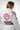 Close-up rear view of the Sakura V3 Women’s Kimono in white highlighting large Red Shield back logo, Equipe detail, and purple Sakura embroidery on shoulder