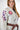 Close-up of Sakura V3 Women’s Kimono in white featuring purple Sakura sleeve embroidery, Red Shield chest logo, and pearl weave fabric detail