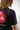 Close-up back view of Sakura V3 Women’s black BJJ rashguard showing Sakura floral shoulder print, purple seam detail, and partial red Gracie Barra shield logo