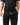 Stacked Button Up in Black — waist close-up showing the front button placket, curved hem, and white woven hem tag over black pants.