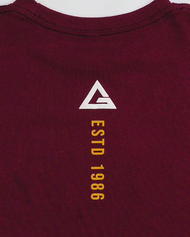 Close-up of back neck detail showing white Legacy G logo above yellow "ESTD 1986" text on maroon fabric.