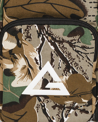 Close-up of camouflage crossbody bag showing the front pocket with white Legacy G logo on a camo pattern background.