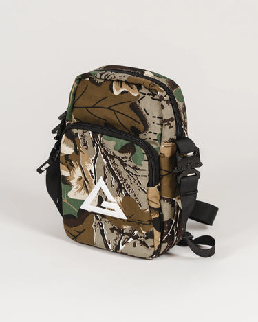 Camouflage crossbody bag with front zip pocket and white Legacy G logo, shown at a side angle with adjustable strap.