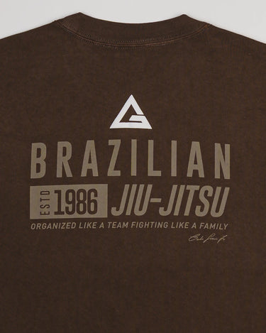Close-up of back print on Tactical Men’s Tee in dark brown showing Legacy G logo above bold “Brazilian Jiu-Jitsu” text with 1986 heritage graphic, displayed on a light gray background.