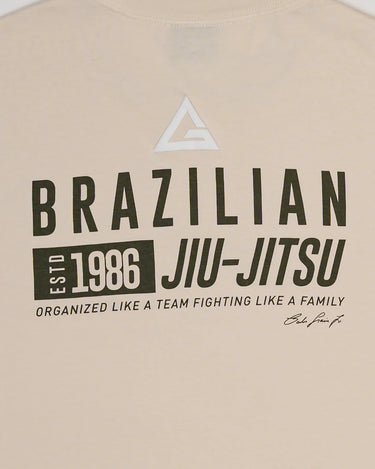 Close-up of the back design on Tactical Men’s Tee in natural beige, featuring Legacy G logo above bold “Brazilian Jiu-Jitsu” text, 1986 heritage graphic, and team motto, on a light gray background.