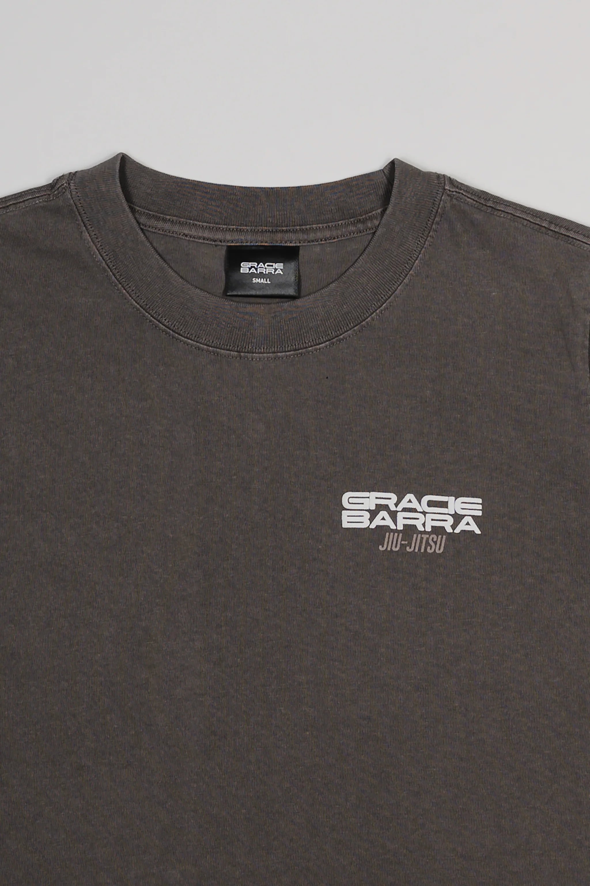 Close-up of the Tactical Women’s Tee in gray featuring the white Gracie Barra Jiu-Jitsu logo on the chest, displayed on a light gray background.