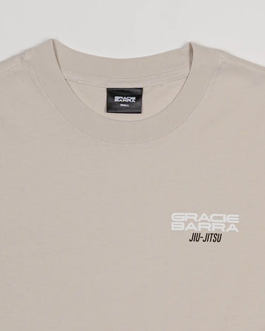 Close-up of beige Tactical Women’s Tee with white Gracie Barra Jiu-Jitsu logo on left chest, crew neck design.