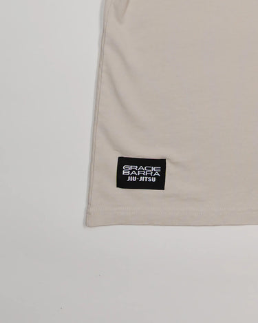 Close-up of lower hem with black woven Gracie Barra Jiu-Jitsu label on beige Tactical Women’s Tee.