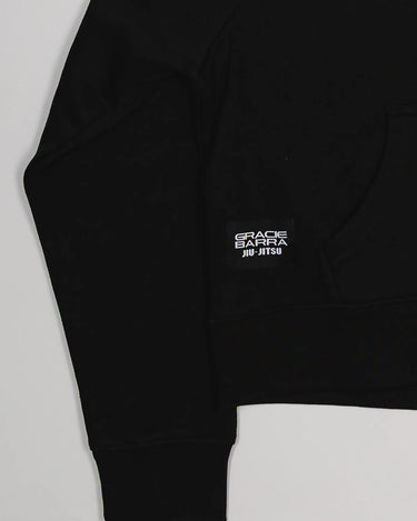 Close-up of hem with white woven Gracie Barra Jiu-Jitsu label on black Tactical Women’s Zip Hoodie.