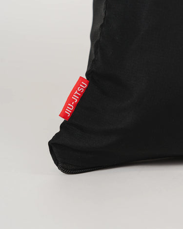 Detail of GB Tech Wash Bag in black showing red woven tab with Jiu-Jitsu branding, part of odor-control ripstop design.