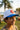 Young student wearing the white Gracie Barra Unified RS youth snapback cap outdoors, showing the blue flat brim and red Barra Shield front patch.