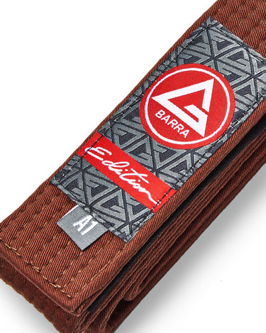 Close-up of the adult brown belt showing the Red Shield patch, Edition label, and size tag with textured belt weave.