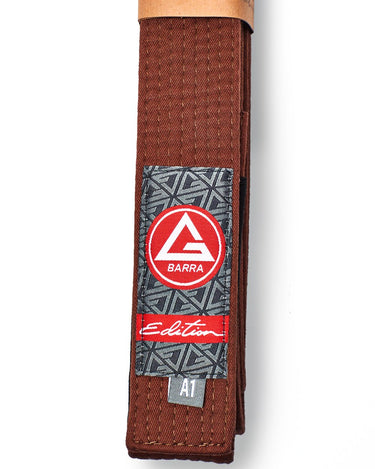Vertical view of the brown GB Edition Adult Belt highlighting the Red Shield patch, Edition label, and belt stitching.