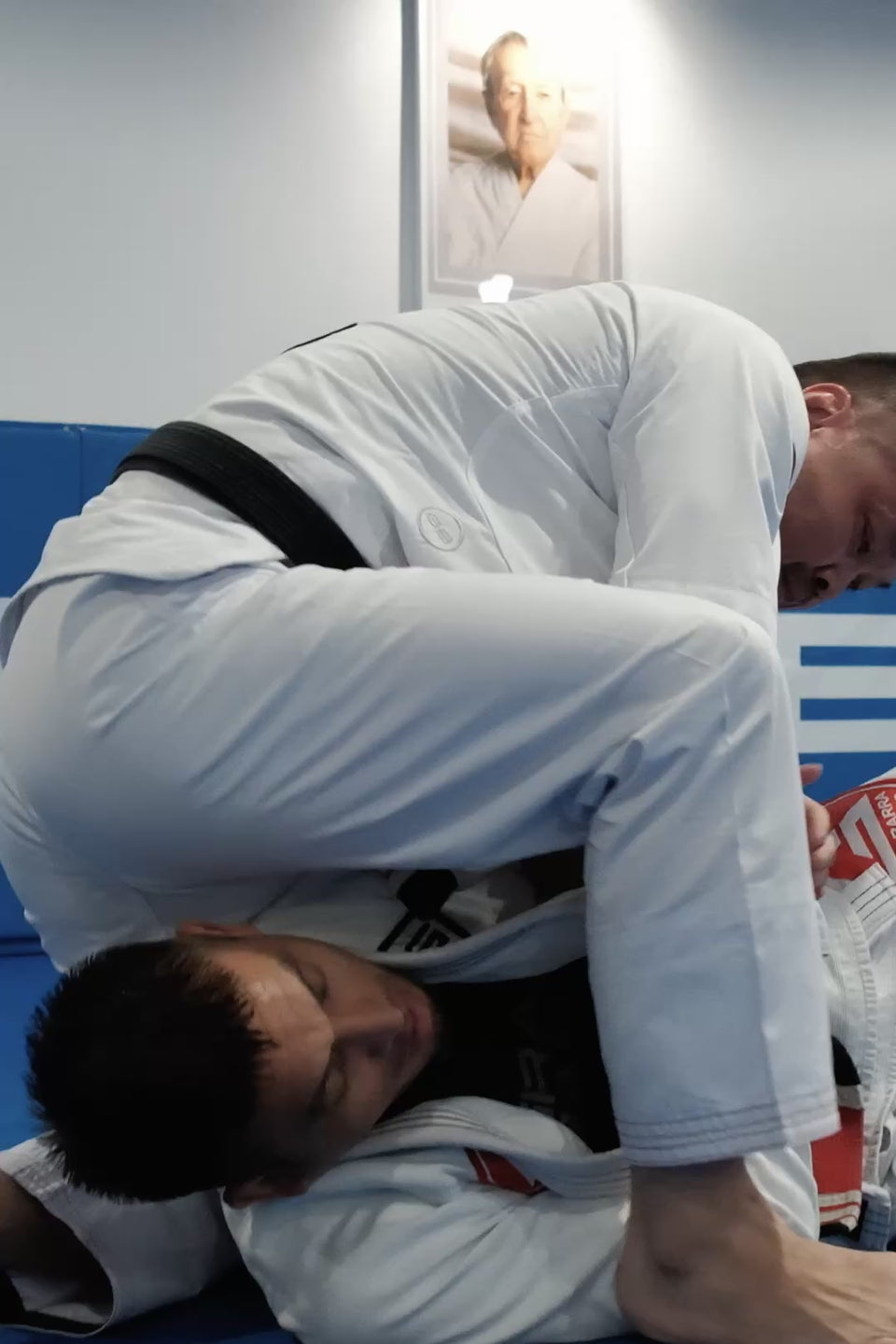 Gracie Barra Professor training in the Ripstop kimono and giving a testimonial, showing the red Barra Shield and EQUIPE GB back patch on the mat.