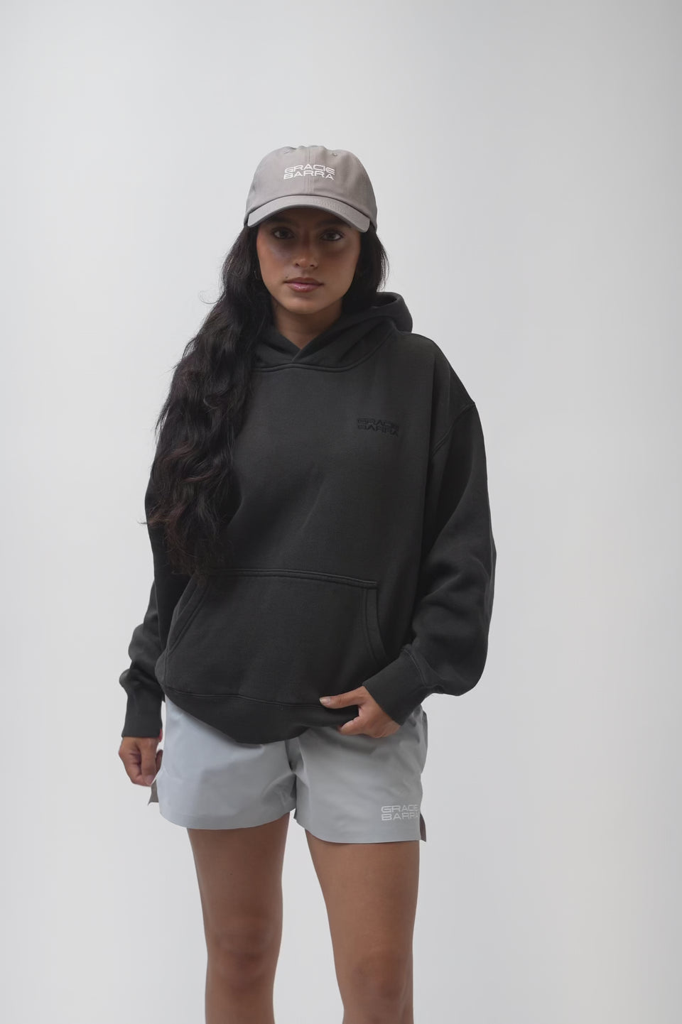 Emblem Womens Hoodie in Black — video of model turning to show the front tonal Gracie Barra emblem, oversized fit, and textured Jiu-Jitsu back detail.
