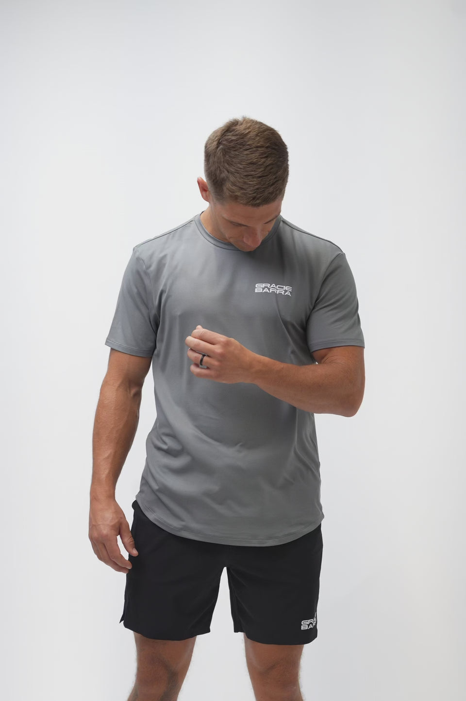 Video of a male model turning to show the front, back, and side of the Flow Men's Tech Tee in dark grey and Frame Men's Short in black