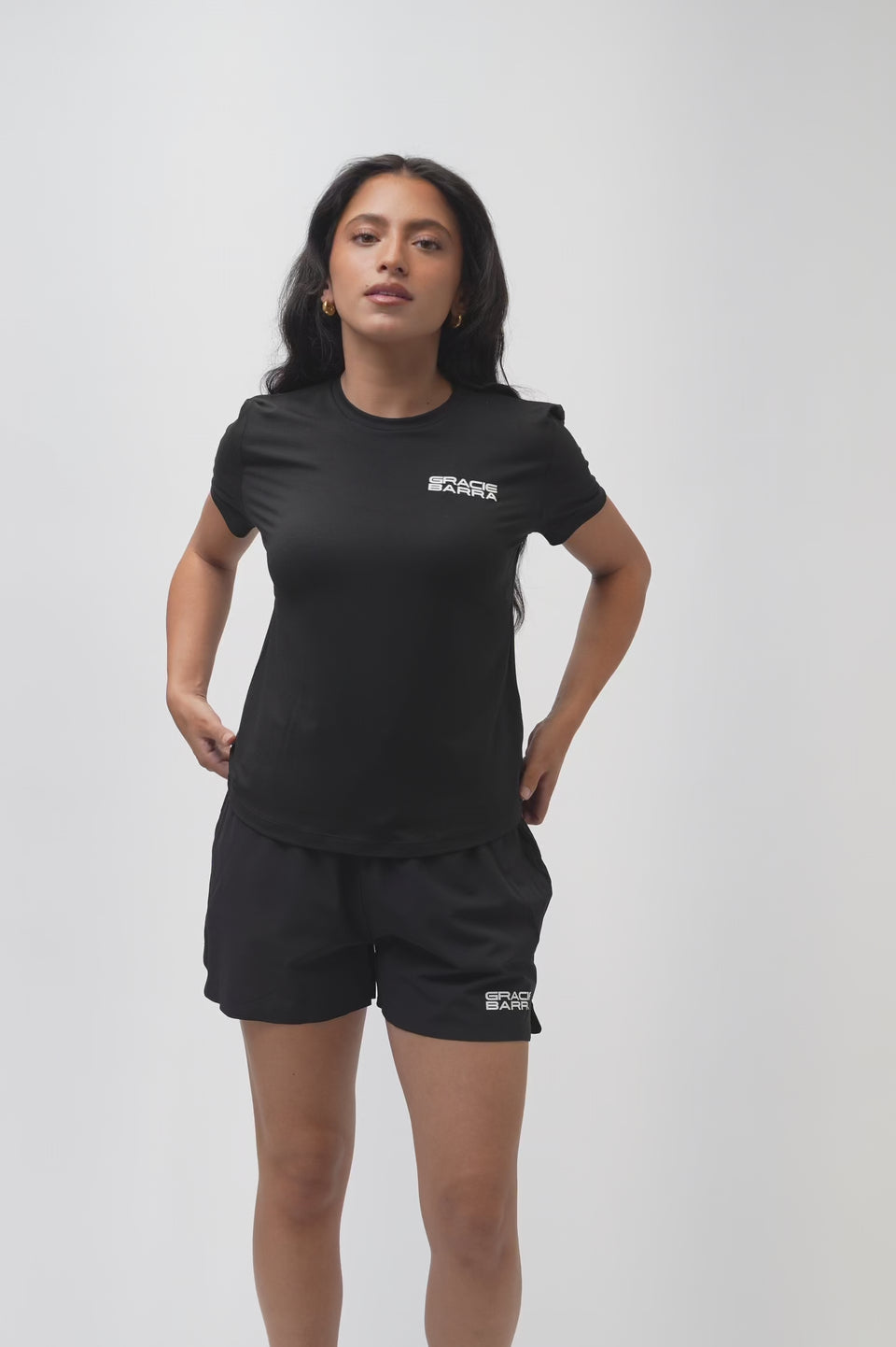 Video of a female model turning to show the front, back, and side of the Flow Women's Tech Tee in black and Frame Women's Short in black